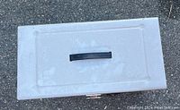 Top view of closed white metal box showing black handle on lid.