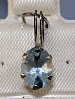 Close-up front view of oval aquamarine pendant set in 10K gold showing gemstone clarity and prong setting.