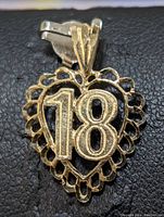 Front view of 10K yellow gold pendant showing '18' design center set in openwork heart.