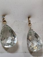 Close-up photo of one earring showing pear-shaped lemon quartz stone and 14K gold hook.