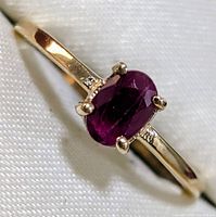 Close-up of oval ruby in prong setting with accent stones