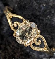 Front view of ring showing oval Zultanite and gold filigree shoulders