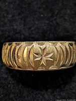 Close-up front view showing the engraved crescent and star motifs on the silver band.