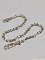 Sterling silver bracelet with geometric pyramid-shaped links and lobster claw clasp displayed on white background, showing overall condition and design detail.