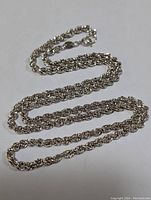 Sterling silver rope chain necklace laid out straight showing the twisted rope design and spring ring clasp.