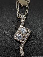 Close-up image of sterling silver necklace pendant with cubic zirconia stones showing details and arrangement.
