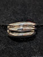 Top side view of the sterling silver multi-band ring on black cloth background.