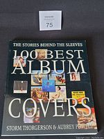 Photo of the book cover showing the title '100 Best Album Covers' by Storm Thorgerson & Aubrey Powell with a collage of various album covers.