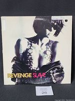 Front cover of Revenge Slave vinyl record sleeve with image of woman and title.