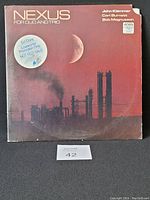 Front of gatefold vinyl album cover showing industrial landscape with moon and promotional sticker.