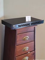 Full front view of Yamaha graphic equalizer unit positioned on wooden chest.