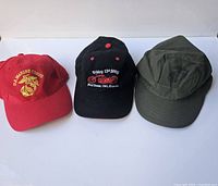 Full set of three different vintage style baseball caps: Marine Corps red hat, black motorcycle event cap, olive green military-style cap.