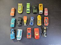 Top down well-lit photo showing all 16 vintage diecast cars and toy vehicles arranged in rows, highlighting types, colors, and condition.
