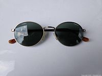 Front view of vintage Randolph Engineering round sunglasses showing metal frame and dark lenses with tortoiseshell-style temple tips.