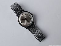 Full view of vintage Timex automatic stainless steel wristwatch with silver dial and date window.
