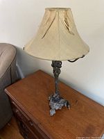 Full view of the vintage table lamp on wooden side table showing fabric shade and metal base.