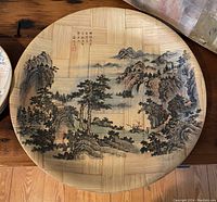 Bamboo plate featuring landscape art with mountains, trees, and river scene