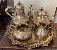 Full tea set on tray showing all five pieces and engraved detailing.