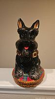 Front view of the black Schnauzer dog cookie jar showing facial details, collar, and tartan cushion.