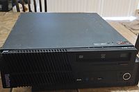 Frontal view of Lenovo ThinkCentre M79 desktop computer showing DVD-RW drive, power button, and jacks.