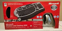 Front image of the sealed box showing wireless keyboard and mouse with branding and key features.