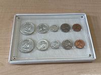 Top down view of a 1960 US coin proof set in a protective case, showing two rows of five coins each.