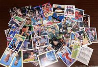 Photo showing a large spread of assorted sports trading cards from various sports such as baseball, basketball, and possibly hockey.