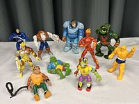 Group of 10 assorted action figures from Ghostbusters and Marvel franchises on a white background.