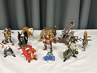 Group of 12 action figures displayed on white background against gray curtain