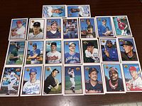 Group of 23 Bowman baseball cards laid out on a wooden surface, featuring various players from the 1989 set.