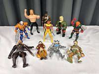 Photo showing all 10 assorted action figures arranged in two rows, featuring various styles and colors, some holding weapons.
