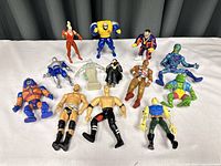 Group of 13 various action figures including Marvel figures showing diversity in character style, colors and poses.
