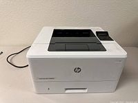 Front view showing the power button, HP logo, paper output tray, and model label LaserJet Pro M402dn.