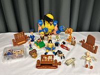 Photo showing the full collection of various toys and figurines including the large Wolverine bank, small furniture, and multiple small characters.