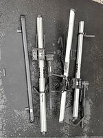 Overview of the Thule bike rack components showing aluminum bars, mounting hardware, and a black component likely for vehicle attachment.