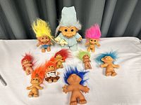 Full lot of 10 vintage troll dolls displaying variety of hair colors and sizes
