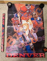 Full view of used 1972 Denver Broncos poster showing three illustrated football players in orange uniforms running with football, large Broncos text in purple, and Denver text in red at bottom. Rolled poster and small black round plastic caps beside it.