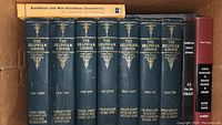 Photo showing the complete set of The Delphian Course antique books in dark blue hardcover with gold text and designs on spine, plus an additional red-volume and a supplementary book titled Euclidean and Non-Euclidean Geometries.