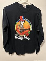 Front view of black long sleeve shirt showing colorful skeleton with guitar and text