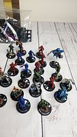 Multiple Halo ActionClix miniatures on base stands showing character names and detailed armor in various colors, arranged on a wooden surface.