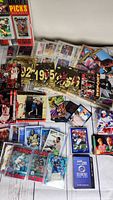 Overview photo showing a variety of basketball, hockey and football trading cards. Visible Michael Jordan cards and others in sleeves, some loose.