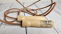 Close-up of wooden handles branded with Everlast logo and leather rope