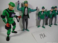 Five Riddler figurines arranged, showing varied styles and poses