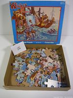 Open box showing loose puzzle pieces inside, pieces depict parts of the colorful Ewok forest scene.