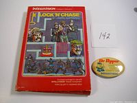 Red Lock 'N Chase game box and yellow Dr. Pepper promotional pin with Intellivision branding.