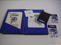 Top view of Skiing game cartridge along with original game box, instruction manual, and two card inserts.