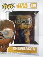Front view of Funko Pop Chewbacca figure in original sealed box, showing figure with gray goggles and detailed fur texture.