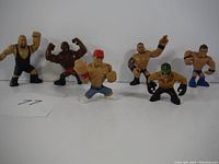 Wide view of six vintage wrestling figures including one resembling John Cena in red cap and others in various wrestling poses