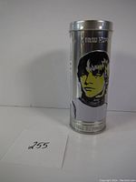 Photo showing the metal cannister with a graphic of Luke Skywalker on the front side, factory sealed condition with slight wear and a small dent visible.