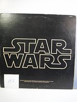 Front cover of 1977 Star Wars soundtrack vinyl album with black background and bold 'STAR WARS' text.